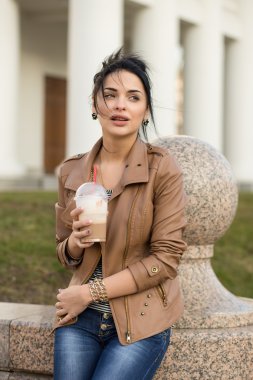 parkta bir bankta oturan deri elbiseli seksi kız.