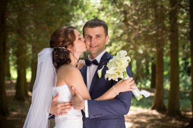 Gelin ve damat, düğün günü açık havada yürüyüş Doğa bahar. mutlu yeni evli kadın ve erkek yeşil park kucaklayan gelin çift. sevgi dolu evlilik çift açık.