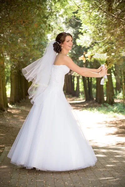 Bela noiva em vestido de noiva e buquê de noiva, mulher recém-casada feliz com flores de casamento, mulher com maquiagem de casamento e penteado. linda noiva jovem ao ar livre. Noiva à espera do noivo. noiva — Fotografia de Stock