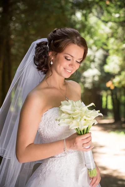 Bela noiva em vestido de noiva e buquê de noiva, mulher recém-casada feliz com flores de casamento, mulher com maquiagem de casamento e penteado. linda noiva jovem ao ar livre. Noiva à espera do noivo. noiva — Fotografia de Stock