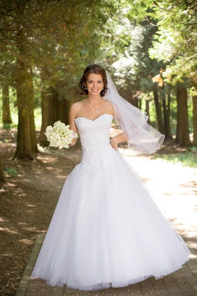 Bela noiva em vestido de noiva e buquê de noiva, mulher recém-casada feliz com flores de casamento, mulher com maquiagem de casamento e penteado. linda noiva jovem ao ar livre. Noiva à espera do noivo. noiva — Fotografia de Stock