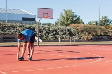 Sporcu antrenman ve müsabakadan önce ısınma egzersizleri yapıyor ve kaslarını esnetiyor. Üstesinden gelme kavramı ve günlük rutin.