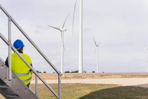 Unrecognizable worker in renewable energy installations looking at electrical generators. Rise and control of energy prices, clean energy concept and future alternatives.