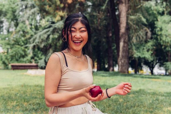 Uśmiechnięta Azjatka Czerwonym Jabłkiem Pikniku Zabawa Zdrowe Jedzenie Przyrodzie Młoda — Zdjęcie stockowe