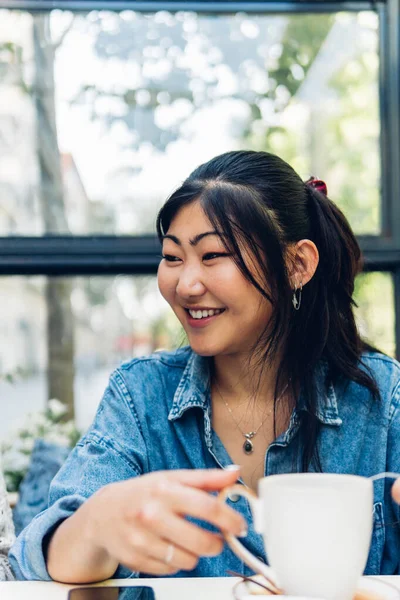 Positive Asian Woman Casual Clothes Smiling While Sitting Table Cup — стокове фото