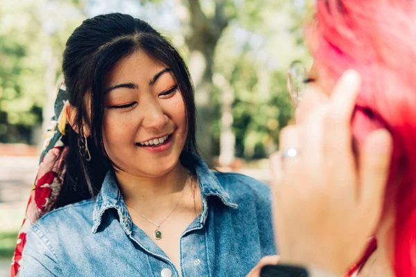 Positive Young Asian Woman Dyed Hair Smiling Talking Her Friend — Zdjęcie stockowe