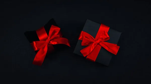 Twee Zwarte Geschenkdoosjes Met Een Rood Lint Vastgebonden Een Strik — Stockfoto