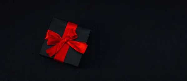 Een Zwart Klein Geschenkdoosje Met Een Rood Lint Vastgebonden Een — Stockfoto