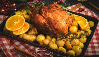 Patatesli tavuk, otlar, portakal ve tarçın çubukları mutfak peçetesinde bir kabın içinde..