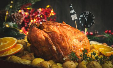 Patatesli tavuk, otlar, portakal ve kağıt saat gece yarısı fırında bir şişe şampanyayla.