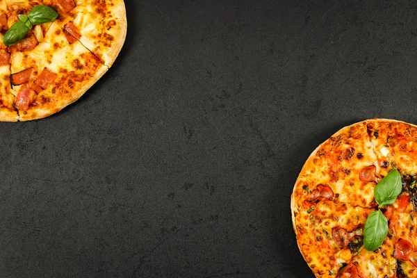 Dos pizzas redondas al horno se encuentran en los lados en un negro —  Fotos de Stock