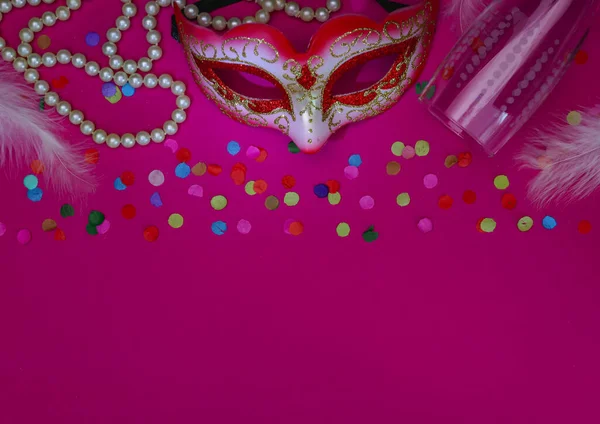 マスケードマスク ホワイトパールビーズ コンフェッティ 空のシャンパングラスは 下のコピースペースがある明るいピンクの背景に列に並んでいますフラットレイアウト マルディグラのお祝いのコンセプト — ストック写真