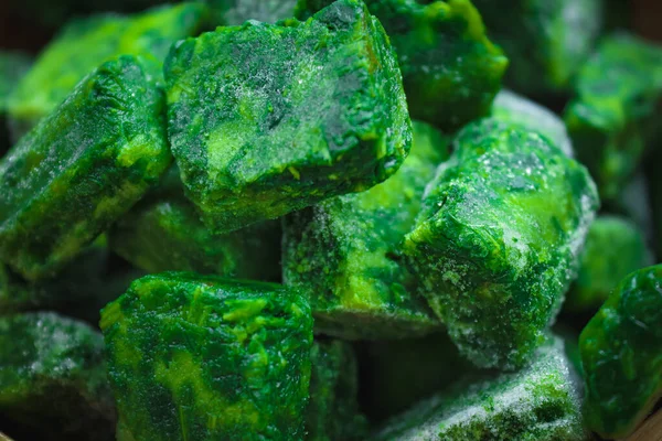 Background from frozen diced spinach with selective focus,flat lay closeup. Healthy food and eco friendly concept.