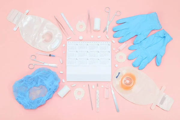 Хирургический набор для хирургии с ежегодным календарем 2022 года и калоприемником на мягком розовом фоне. — стоковое фото