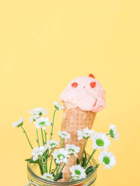 Gözleme külahında ev yapımı ahududu dondurması. Sarı arka planda cam bir kavanozda yaz çiçekleri var. Üzerinde de fotokopi alanı var. Dondurma konsepti, şerbet, yaz, bayrak, pastel cennet.