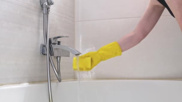 一位穿着黄色手套的高加索裔年轻女子的手在流动的水中冲洗海绵 然后在浴室边缘扭动 慢慢地侧视 清洁浴室的概念 — 图库视频影像