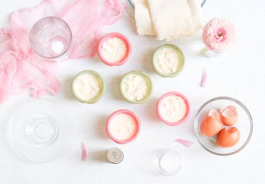 Yedinci adım. Yumurta hamurunu süzme peynir, süt, rendelenmiş peynir ve silikon kabuklarda dilimlenmiş pide ekmeği mermer bir masada pita ekmeği, yumurta kabuğu, boş bardak ve çiçek ile karıştırıp yakın plan yapın. Ev yemeği konsepti, tembel achma..