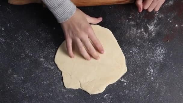 Mała Dziewczynka Obraca Okrągłą Pizzę Domowej Roboty Ciemnym Stole Wałkiem — Wideo stockowe