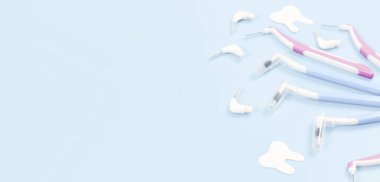 Sağ tarafta küçük diş fırçaları ve kağıt dişler sol tarafta fotokopi alanı olan yumuşak mavi bir zemin üzerinde, üst katın yakın çekimi..