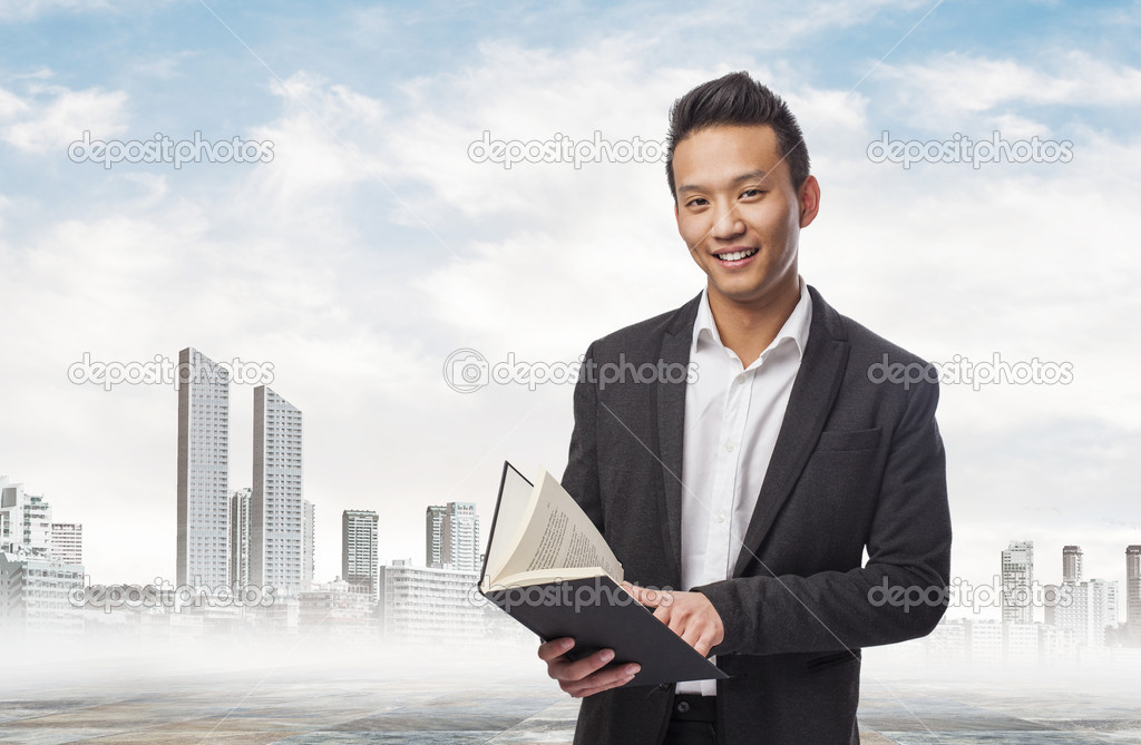 Asian business man holding a book