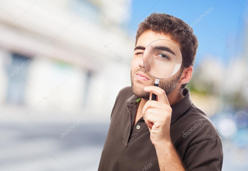 Man looking through magnifying glass