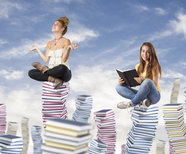 Students on book piles — Stock Photo, Image
