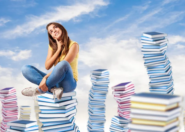 Femme assise sur une pile de livres — Photo