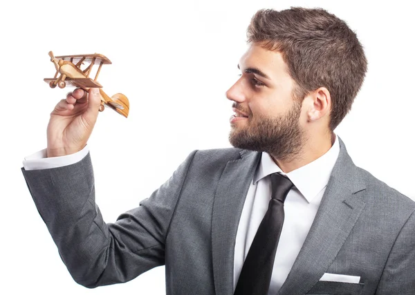 Business man holding wooden airplane — Stock Photo, Image