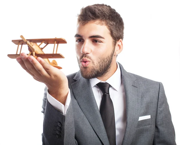 Hombre de negocios sosteniendo avión de madera — Foto de Stock