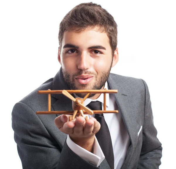 Business man holding wooden airplane — Stock Photo, Image
