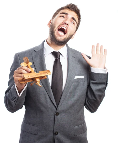 Business man holding wooden airplane — Stock Photo, Image