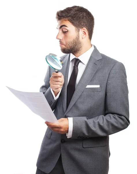 Business man looking through magnifying glass — Stock Photo, Image