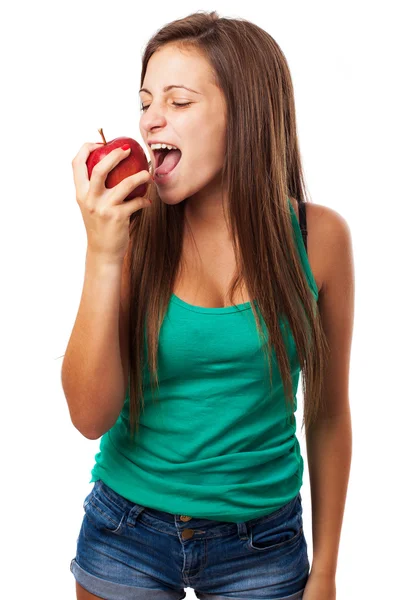 Женщина, кусающая красное яблоко — стоковое фото