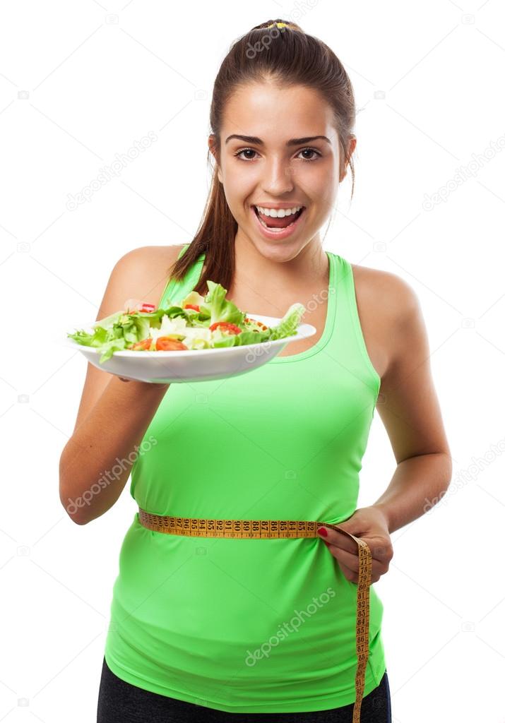 woman measuring and holding salad