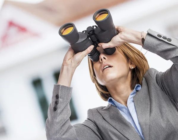 Woman looking through binoculars — Stock Photo, Image