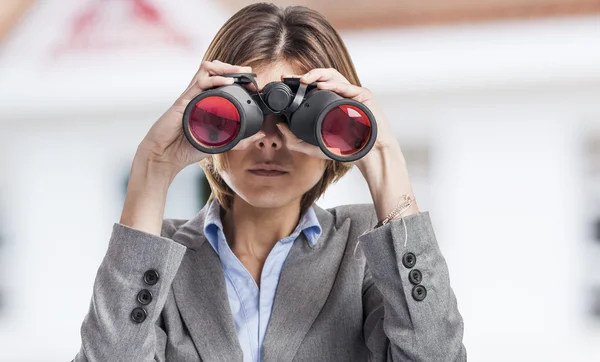 Vrouw die door een verrekijker kijkt — Stockfoto