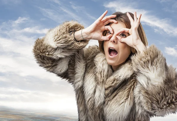 Woman looking through fingers — Stock Photo, Image