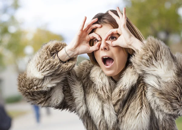 Mujer mirando a través de los dedos —  Fotos de Stock