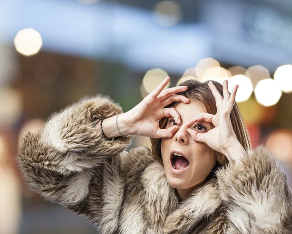 Mujer mirando a través de los dedos —  Fotos de Stock