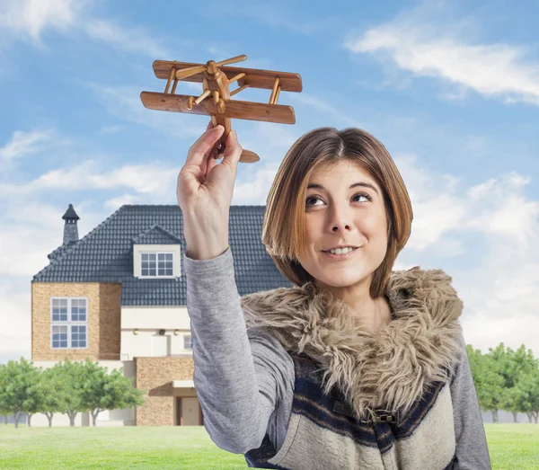 Femme jouant avec un avion en bois — Photo