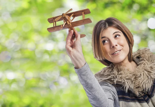 Vrouw spelen met houten vliegtuig — Stockfoto