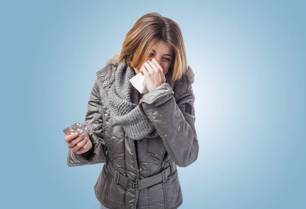 Mujer estornudando y sosteniendo medicamentos — Foto de Stock