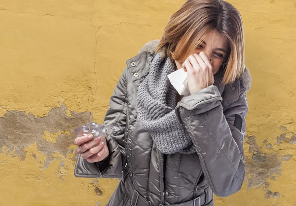 Mujer estornudando y sosteniendo medicamentos — Foto de Stock