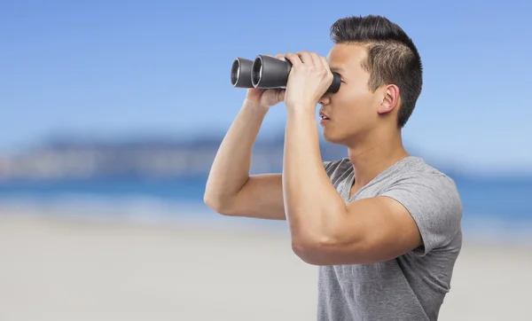 Man kijkt door een verrekijker — Stockfoto