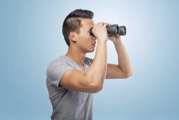 Man looking through binoculars — Stock Photo, Image