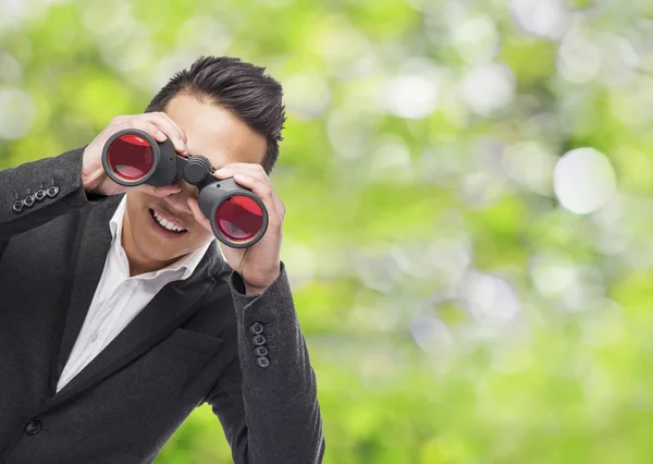 Man looking trough binoculars — Stock Photo, Image