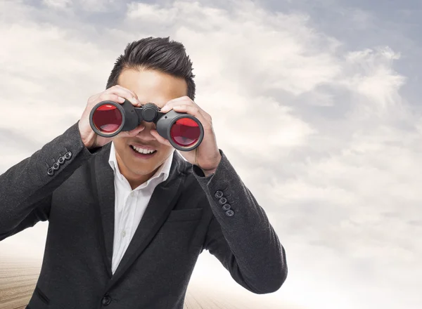 Man looking trough binoculars — Stock Photo, Image