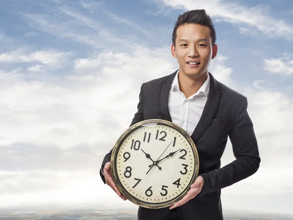 Business man holding clock — Stock Photo, Image