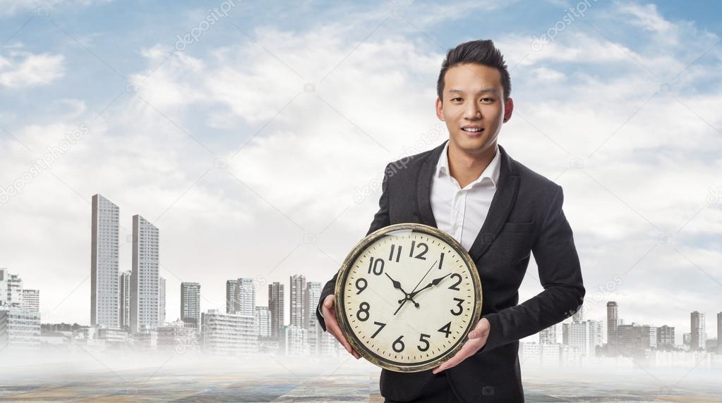 Business man holding clock