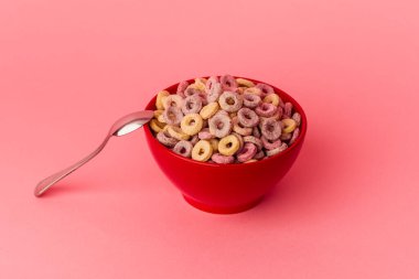 Mısır gevreği kasesi pembe arka planda izole edilmiş.